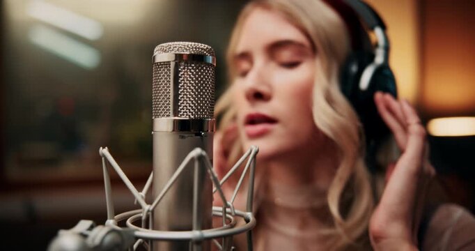 Microphone, singing and woman in booth with headphones for recording music with talent for album. Singer, artist and female musician with audio tech for production on song with media in sound studio.