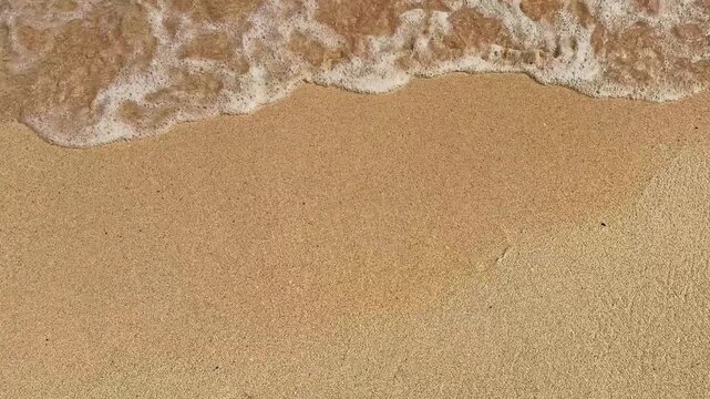 The waves wash away the 2026 inscription in the sand, demonstrating the inevitability of the end of the year.