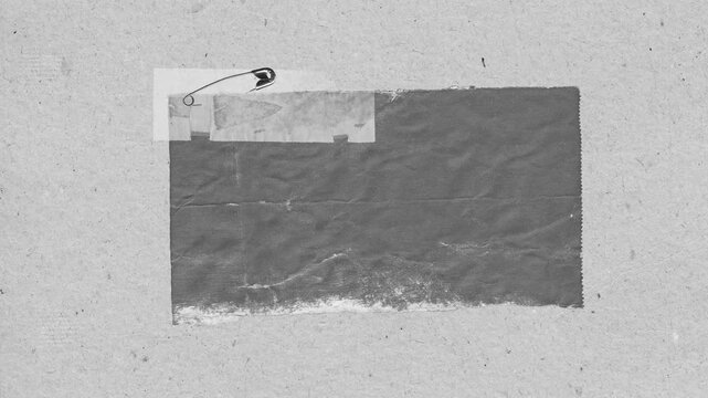 Abstract composition of textured paper, safety pin and torn edges in monochromatic grayscale