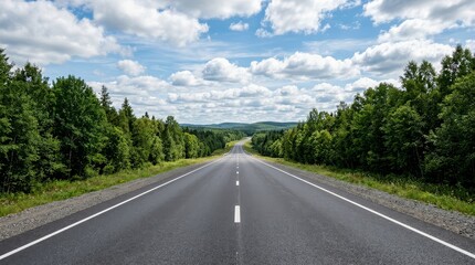 Fototapeta premium Empty asphalt road winding through a lush green forest under a bright blue sky with white clouds on a sunny day in a peaceful rural landscape
