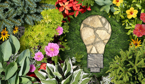 Gardening Ideas and garden Background with an ornamental landscaped flowerbed and spring gardening concept shaped as an idea lightbulb with a mowed lawn and grass representing environmental design or 
