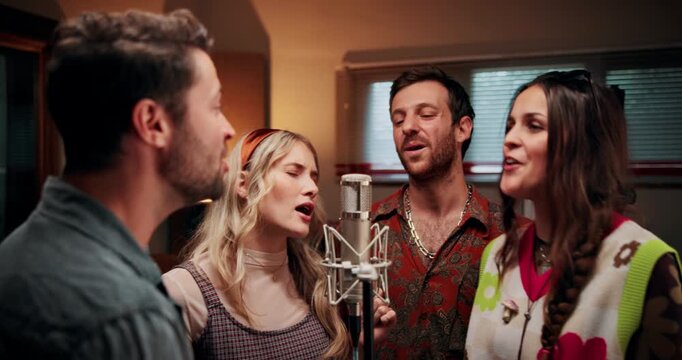 Microphone, singing and group of people in studio for recording music with talent for album. Singers, artists and musicians with audio tech for production on song with media in sound lab for radio.