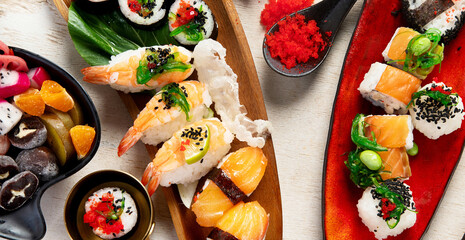 A table with Asian food, sushi, rolls, desserts. © bit24