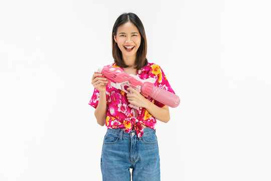 Songkran festival in Thailand, Cheerful young woman wearing summer wearing floral shirt with a pink water gun isolated on white background