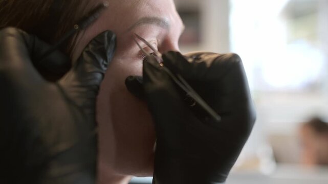 Professional eyebrow shaping and correction. An attractive mature woman receives a facial treatment and makeup application at a beauty salon. Perfect architecture eyebrows.