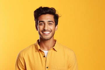 Obraz premium Young man standing, smiling broadly at the camera on a yellow background