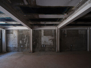 Raw industrial basement with low concrete beams and dim lighting © Namsun