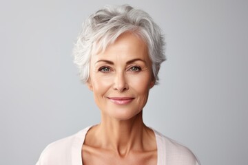 Fototapeta premium Senior woman with short grey hair smiling, representing graceful aging and well being