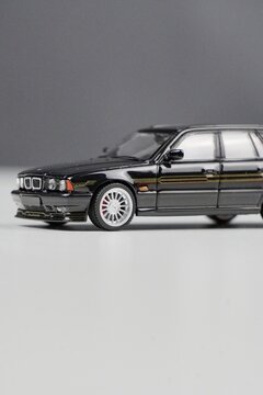 Scale model of a black BMW E34 M5 on a gray background