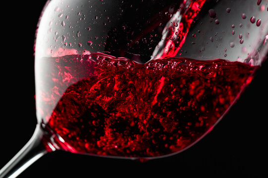 Red wine is poured into a glass.