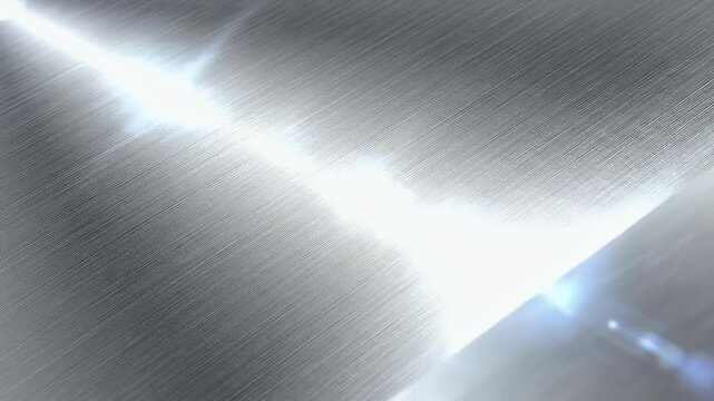 A close-up shot showcases a brushed metal surface with a bright, diffused highlight creating a dynamic and textured visual.