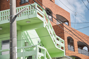 Colorful exterior staircase on residential building in tropical urban neighborhood © Namsun