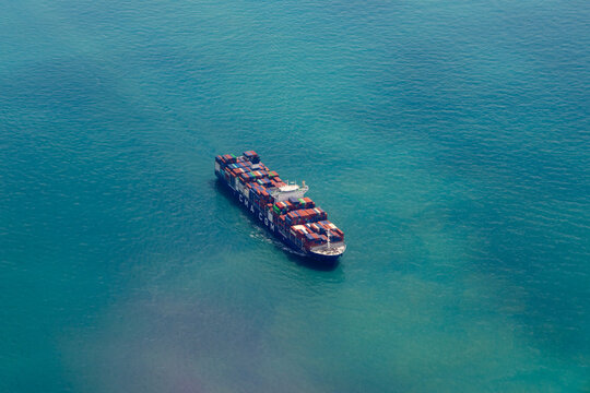CMA CGM container ship navigating through turquoise blue ocean water. Global logistics and international maritime trade featuring cargo vessel in open sea.