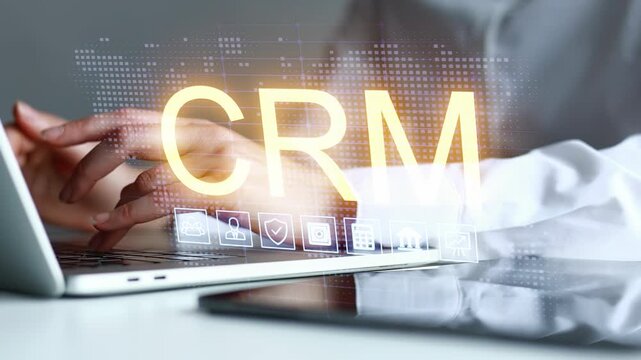 Business person using laptop with CRM software on display while hands show focus on work.