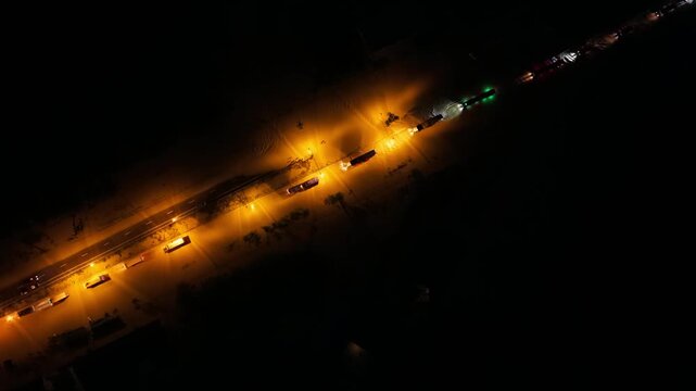 Aerial top view night flooding on road, traffic jam on highway near of city Mu Ban Thep Thani, Chumphom Thailand.