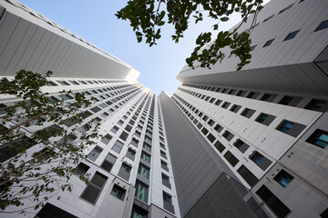 Low angle view up between tall modern residential towers and sky © Namsun