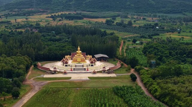 Aerial view Huay mongkol temple at sunset: golden buddha statue in Hua Hin, Thailand.