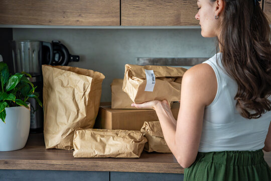 Woman holding a labeled grocery bag with the word Recept, meaning recipe in another language. Concept of convenient meal kit delivery with pre-portioned, ready-to-cook ingredients.