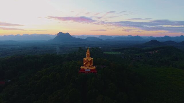 Aerial view Wat Khao Chedi Wisai Tri Rattanaram, Buddhism monument Gold Big Buddha on Sunset in Thailand.