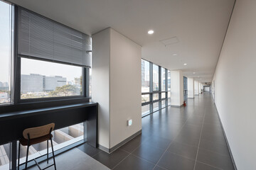 Fototapeta premium Sunlit glazed corner with city view and dark tile floor