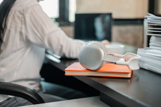 A sleek office desk featuring headphones and notebooks, capturing a modern and productive workspace environment.