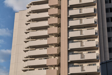 Close apartment facade with repeating balconies in warm afternoon light © Namsun