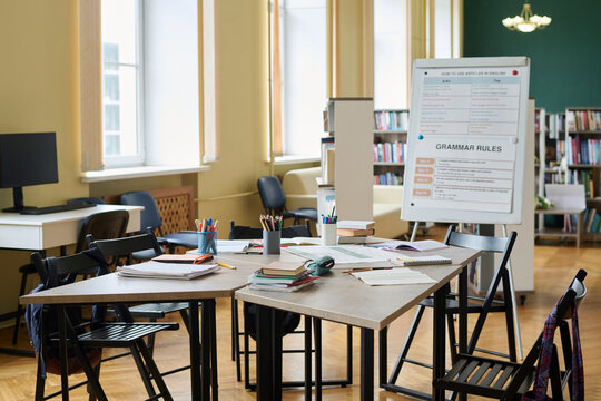 Empty classroom interior with desks and educational materials on a board