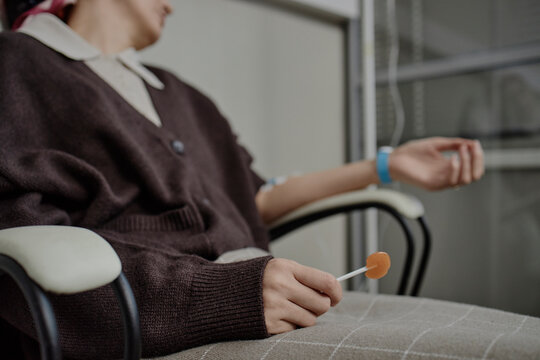 Patient receiving chemo therapy with IV drip and lollypop at clinic