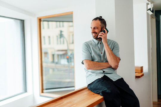 Self-employed developer talking on phone in modern office