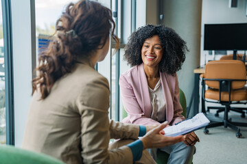 Obraz premium Businesswomen discussing documents in modern office
