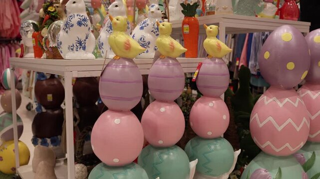 Vertical screen colorful easter eggs stacked with small chick figurines and pastel decorations arranged in playful composition creating cheerful spring holiday shopping atmosphere