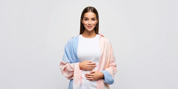 Young woman standing with hands resting gently on her stomach in a calm pose