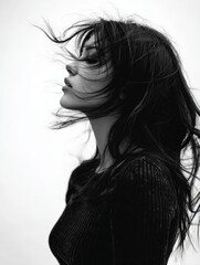 Naklejka premium a monocrome portrait of a woman with black hair blowing in the wind