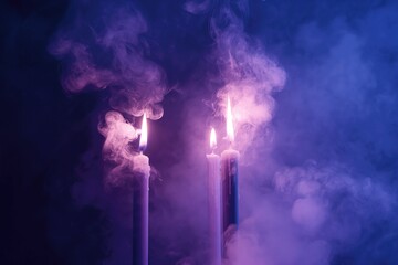 Fototapeta premium Two Tall Candles with Purple Smoke Rising on Dark Moody Background