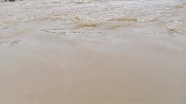 Muddy River: A churning river of muddy water cascades in a tumultuous display of raw power, creating a mesmerizing scene of nature's formidable force.