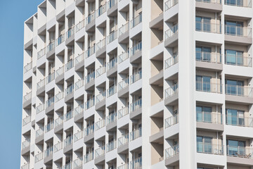 White apartment facade with repetitive square balconies in sun © Namsun