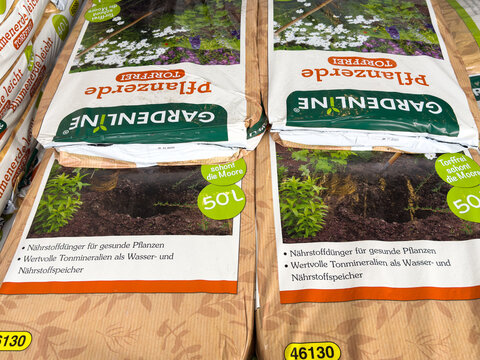 Villach, Austria - March 23, 2026: Garden soil bags labeled "Gar Gardenline" stacked in a retail setting, showcasing product details and packaging design for gardening enthusiasts