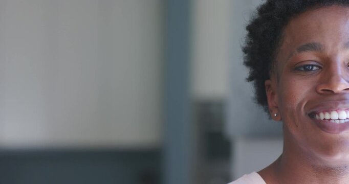 African American man entering right frame in corridor, smiling, showing stud earring, copy space