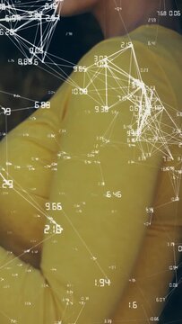 Vertical video: Woman uncrossing arms and turning to show profile while data overlaying yellow top