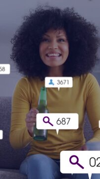 Vertical video: Woman drinking bottle on sofa, count bubbles updating causing cheer for marketing