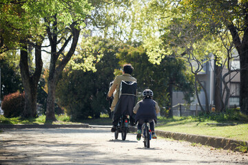 Obraz premium 春の公園で自転車を乗る子供と父親の姿