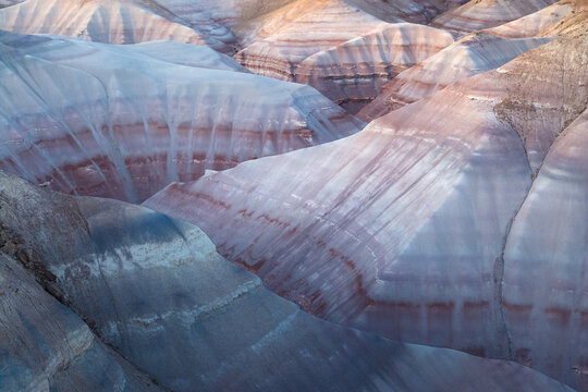 Aerial view of the mesmerizing and undulating landscape, where bands of pastel blues, purples, and reds create a painterly tableau of natural artistry, Hanksville, Utah, United States.