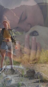 Vertical video: Merging petting overlay, woman in yellow jacket hiking with partner on trail, dog