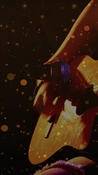Vertical video: Guitarist playing guitar as camera zooming, sparks around guitar and spot for music