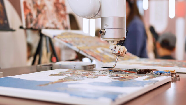 Robot arm painting art on canvas at an artificial intelligence creativity exhibition