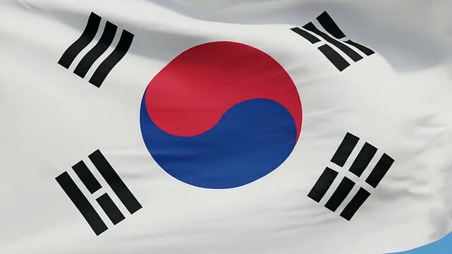 A national flag with a red and blue circle waving against a clear blue sky