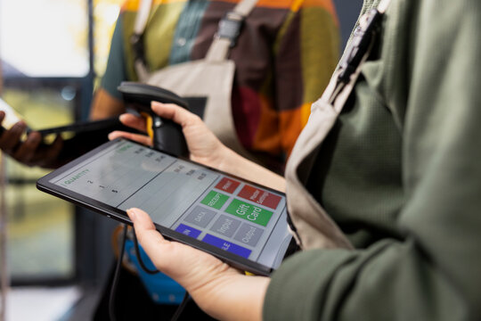 Close up of workers checking inventory with tablet and scanner, verifying airway bills on parcels and supporting e-business operations with shipment labels. Distribution logistics for orders.