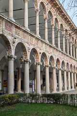 Naklejka premium Elegant cloister arcade with columns and green lawn in Italy