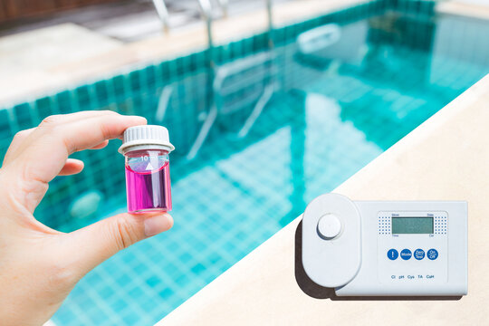 Digital water tester and pool tester on swimming pool edge with space on blue water background, summer outdoor day light, water quality testing technology