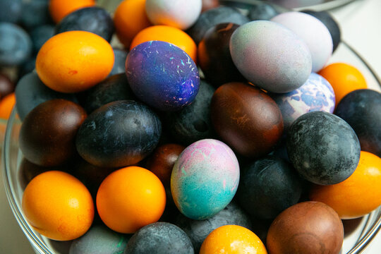 Colorful dyed Easter eggs in glass bowl &ndash; traditional holiday decoration